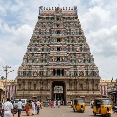 Detailed view of the intricate carvings on the towering Eastern Gopuram (Rajagopuram) of Arunachaleswarar Temple against a blue sky.