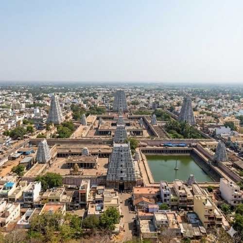 Wide panoramic view overlooking the massive Arunachaleswarar Temple complex and the surrounding Tiruvannamalai town from an elevated mountain viewpoint.
